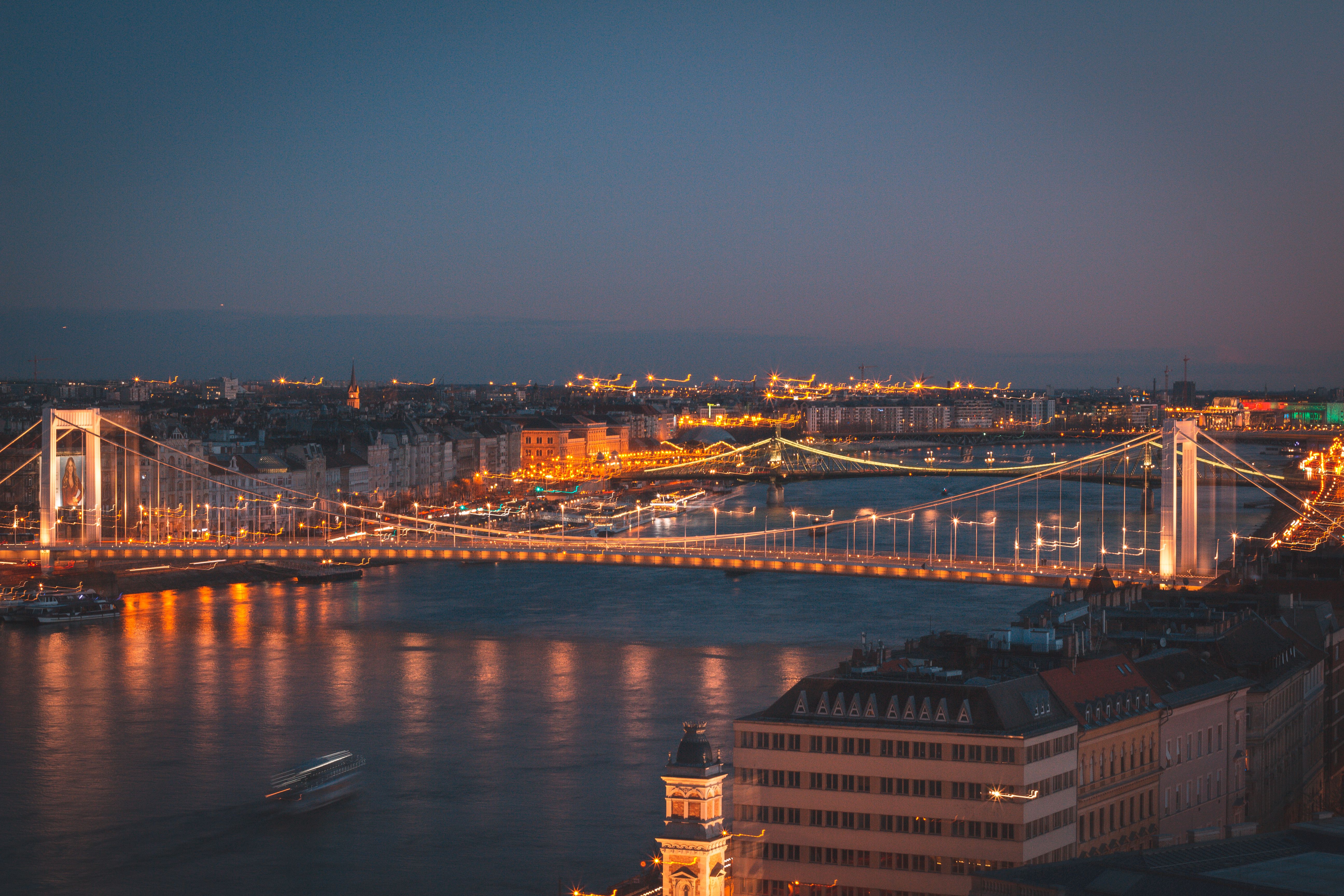 Night view of Budapest city with an illuminated bridge reflecting on the Danube River