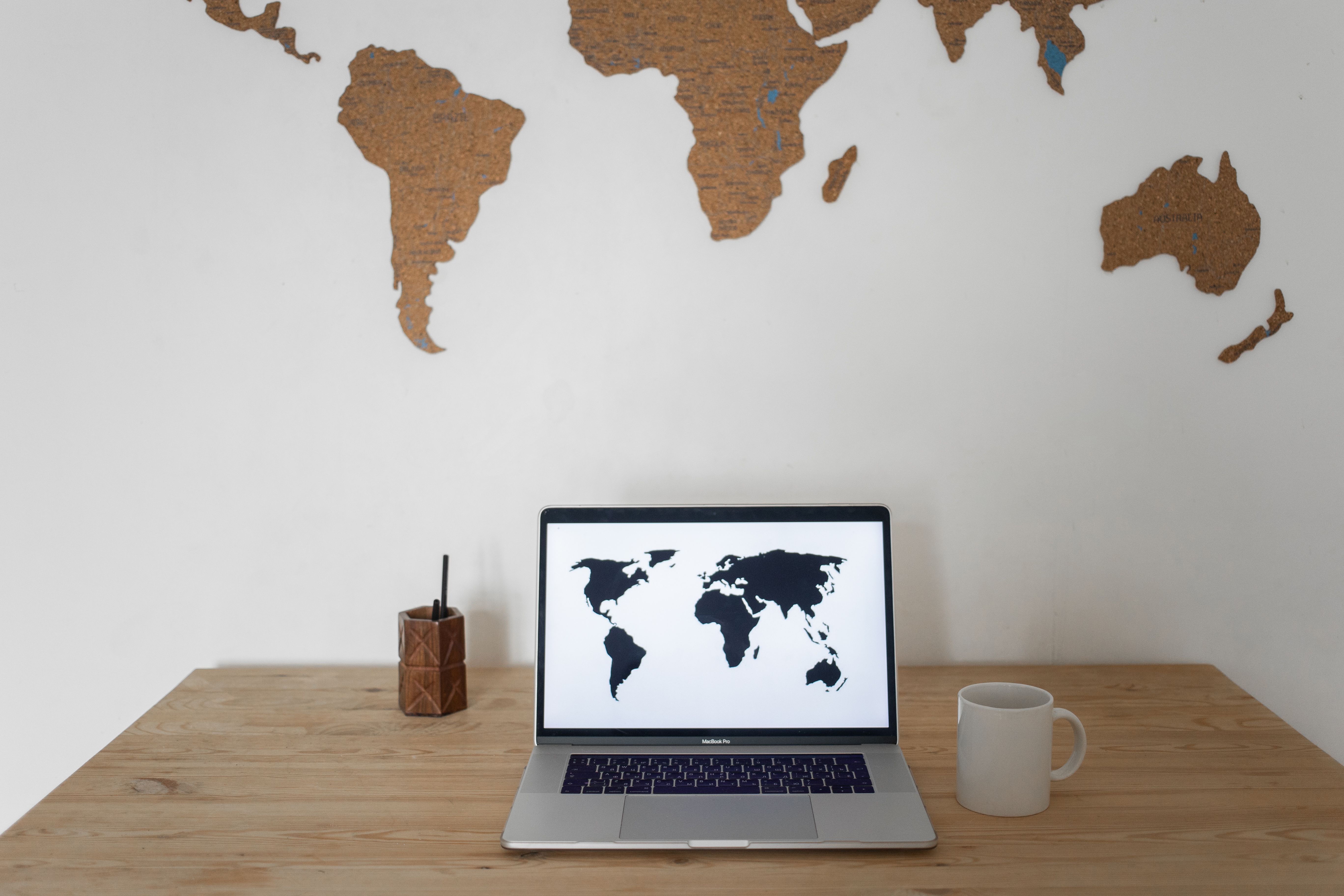 Laptop screen showing a world map symbolizing global distributed teams and international networks