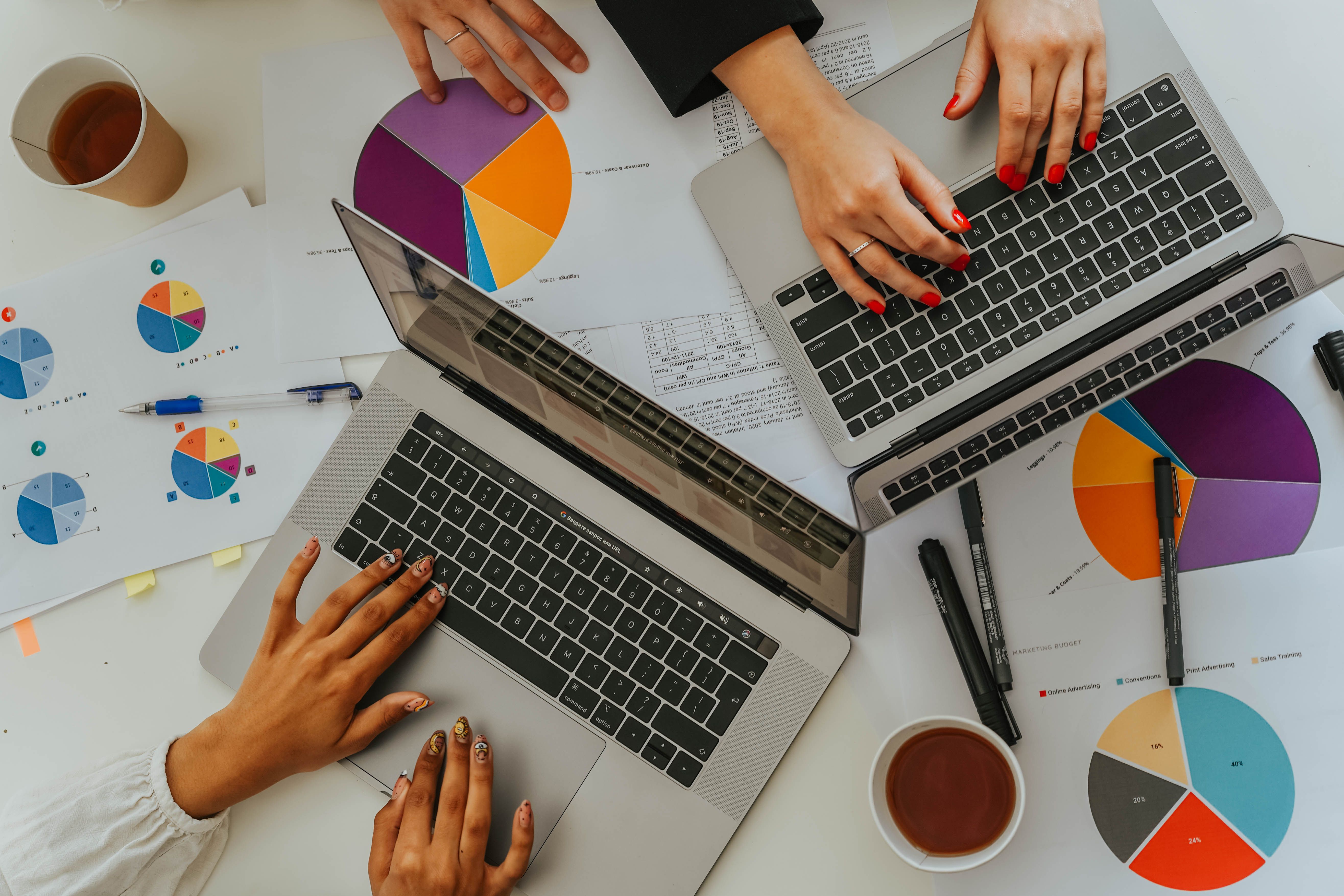 Overhead view of a distributed team reviewing data dashboards and metrics on laptops