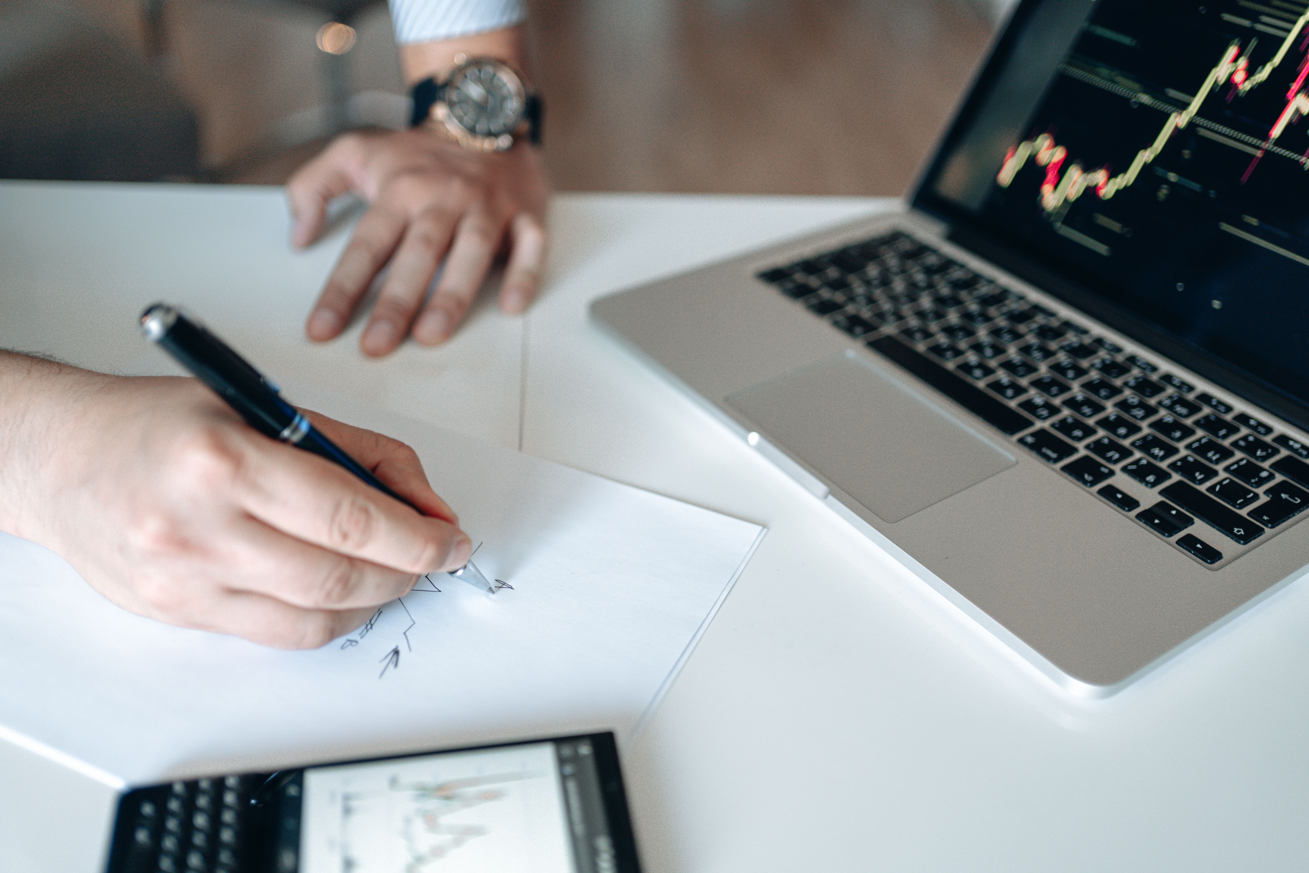 Business owner reviewing financial figures on a laptop and calculator, illustrating routine bookkeeping and forecasting.