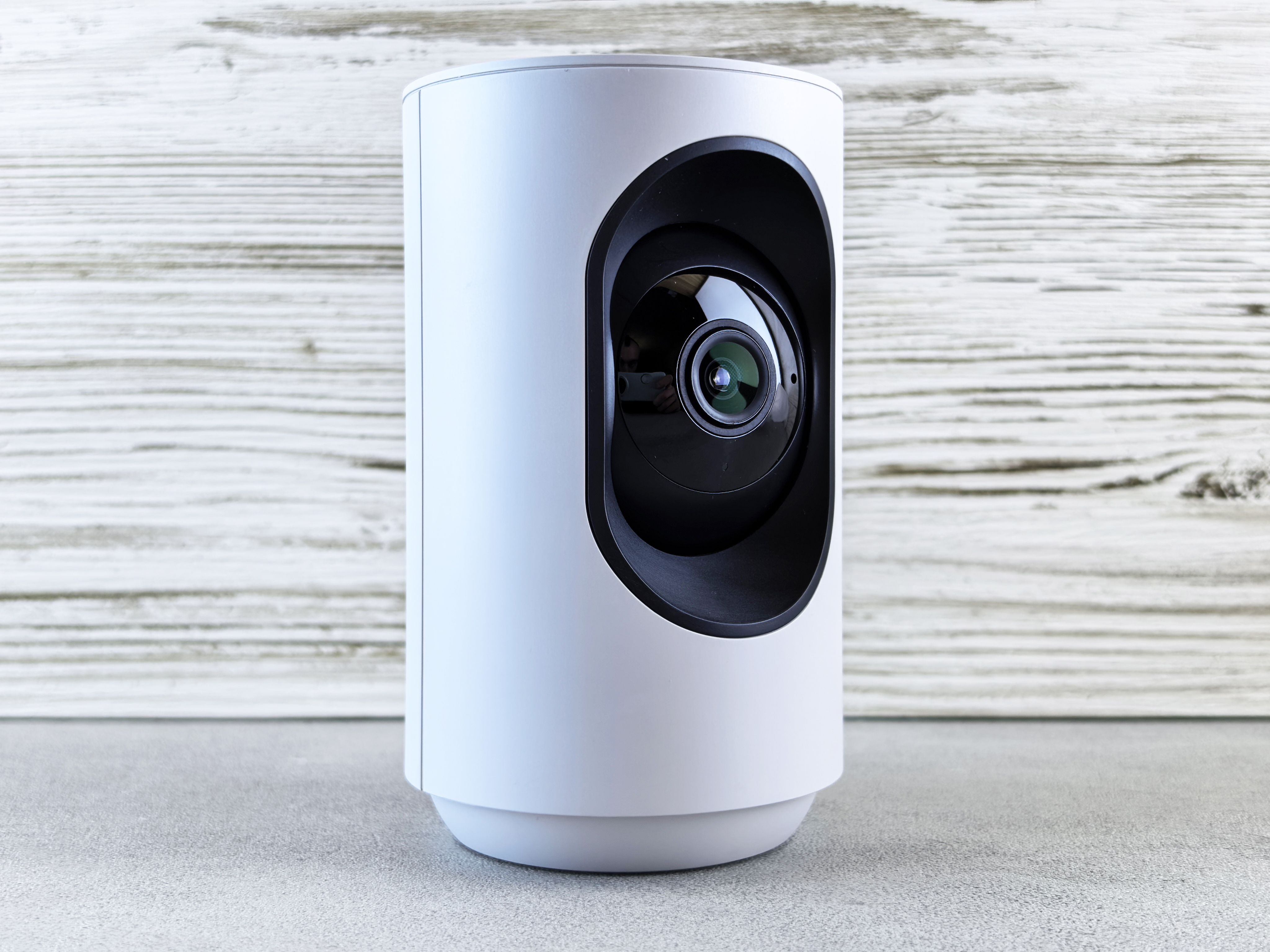 Close-up of a white indoor security camera used for home monitoring.
