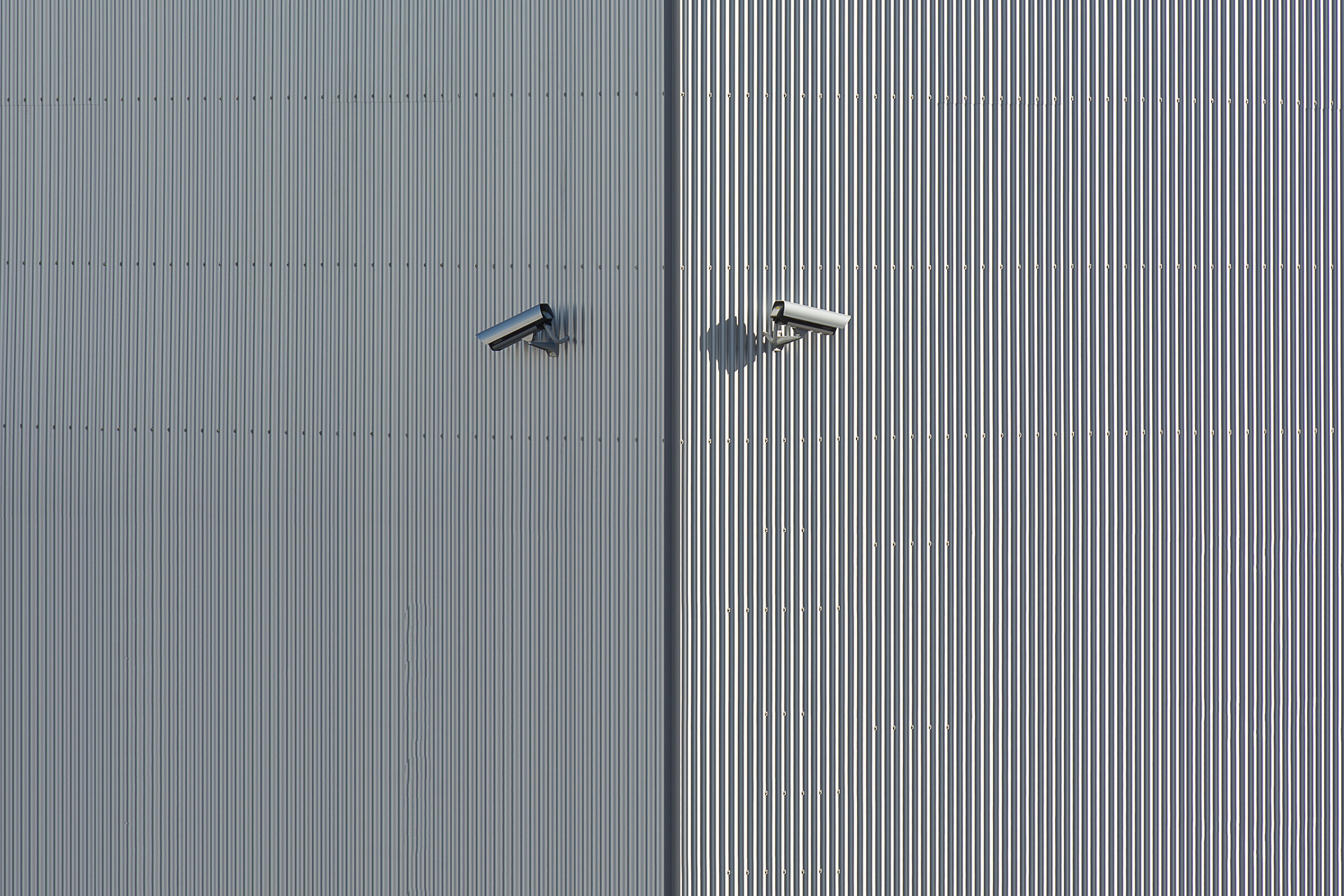 Two security cameras mounted on a wall, representing deliberate camera placement around a property.