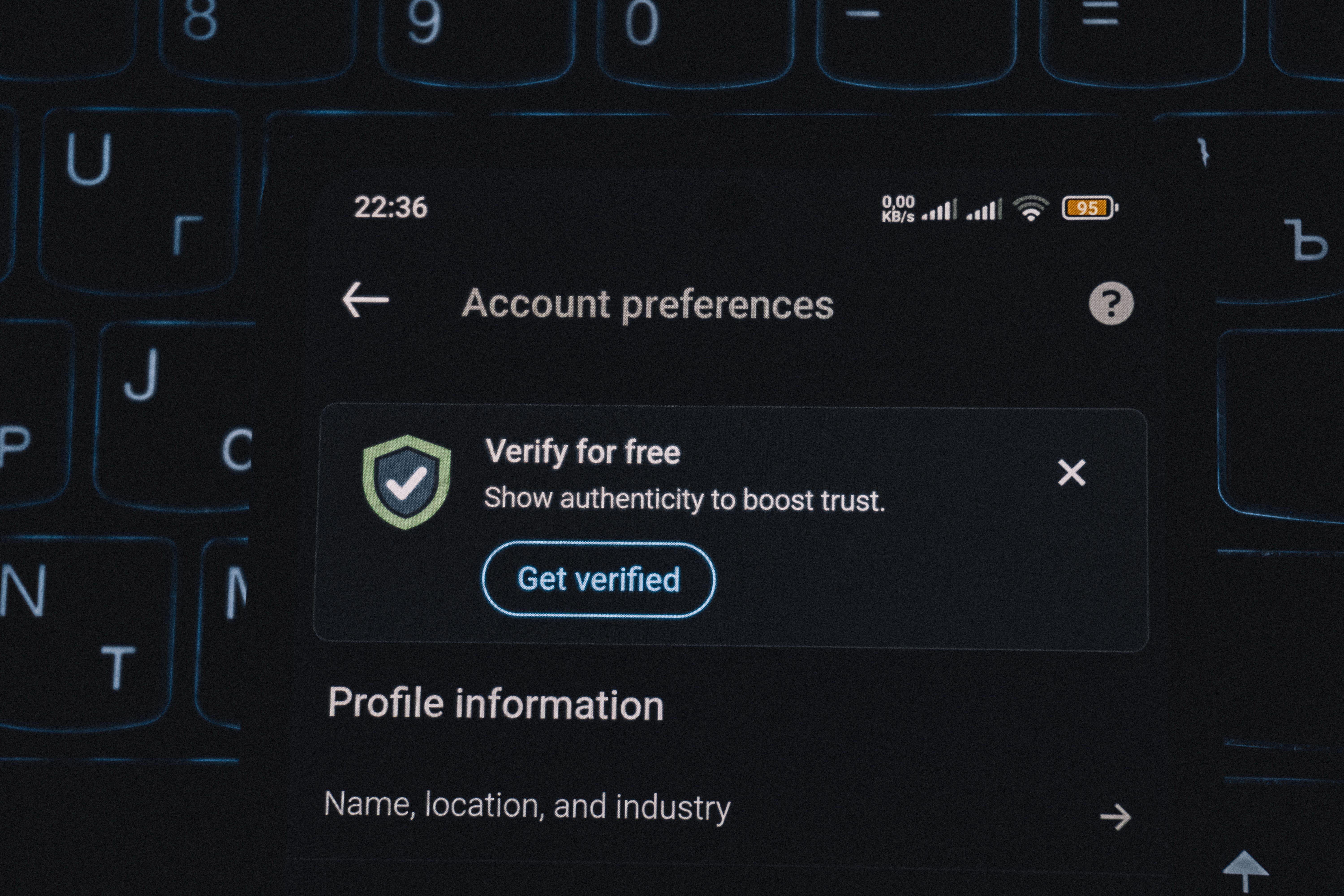 Close-up of a smartphone showing an account verification alert, representing authenticity checks for brand identities.
